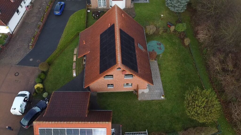 Luftaufnahme eines Hauses mit Photovoltaikmodulen auf dem Dach